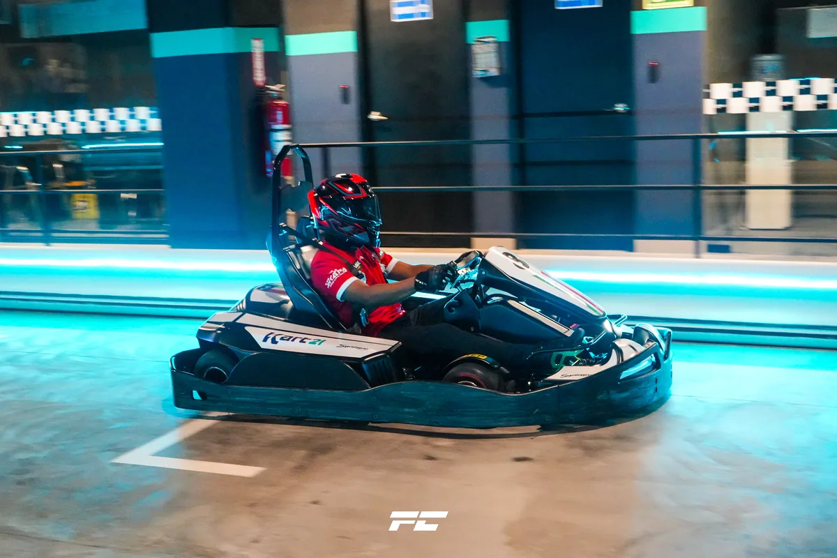 Kart eléctrico tomando una curva en la pista con neón de Kart21