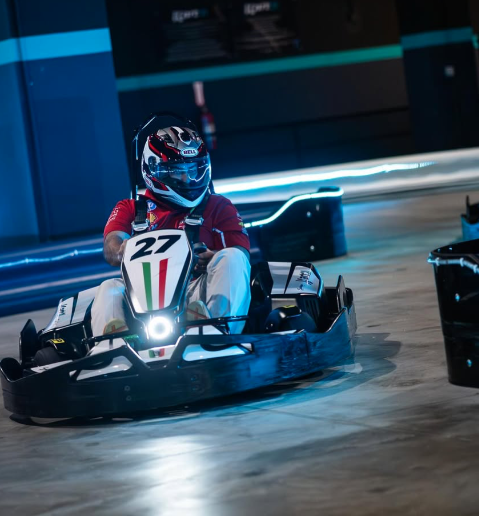 Carrera de karts con tablero de tiempos en vivo bajo luces neón